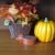 This grouping of a basket with faux fall leaves, a pumpkin, and a vintage tin are on the sideboard in the dining room. 
