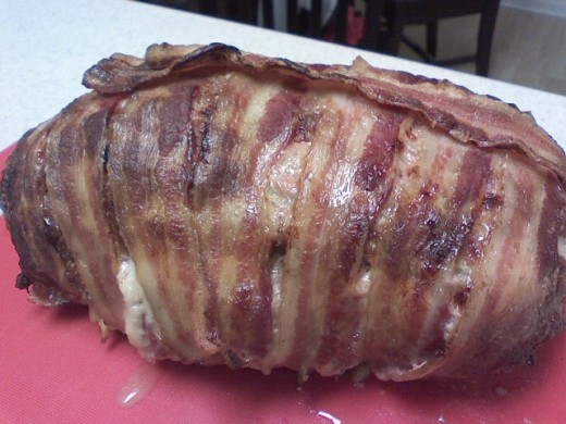 A stuffed meatloaf covered in bacon strips