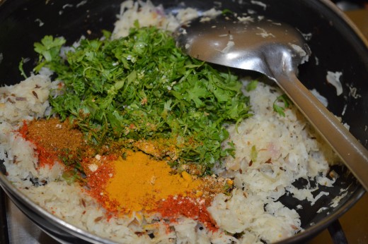 Step five: Add turmeric powder, dry mango powder, red chili powder, sugar, salt, garam masala powder, and chopped coriander leaves.