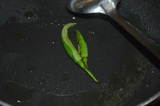 Step one: Saute whole green chilies in oil till it changes color