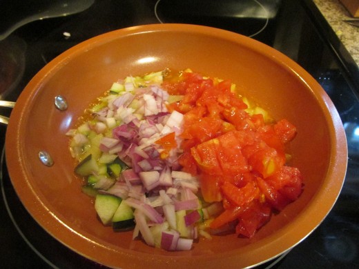 Sautéing  vegetables for rice and tomatoes.