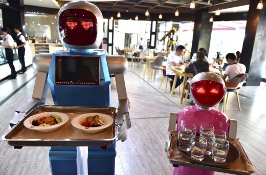Robots working as waiters and waitresses, serving food and drinks.