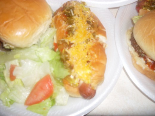 Ultimate burgers and hot dogs with fresh lettuce and tomato salad 