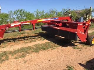This attaches to the back of a tractor and then is pulled along the rows of cut hay, picking up the hay and squeezing the morning dew out of it.