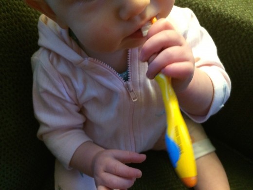 Chewing on her toothbrush helps Imogen massage her gums and get used to the toothbrush.