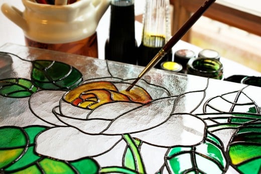 Artist painting glass.