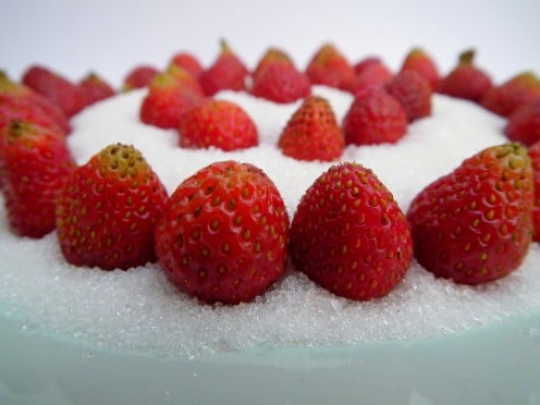 Strawberries seen on a bunch of white, refined sugar.