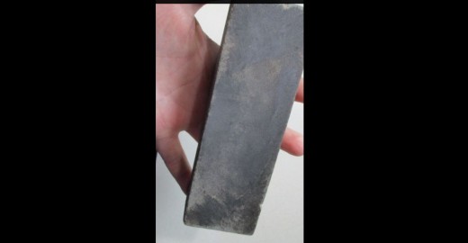 This is a sharpener called the wet stone. The knife is rubbed on it.