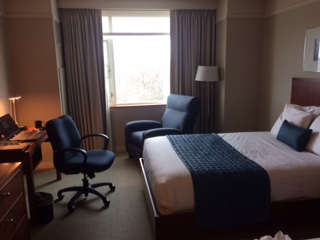 view of one of the queen-sized beds,desk and lounger as seen from the entrance.