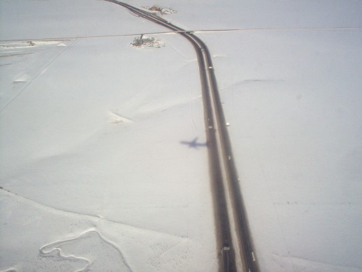 See the shadow of the plane flying over Denver reflecting in the snow.