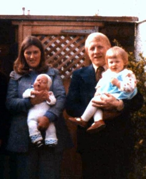My husband and I with our two children who were born just one year apart. We were taller and thinner than we look in this photo scanning seems to have squashed us up a little. 
