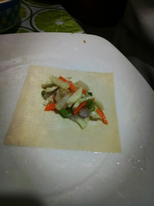 2. Sprinkle some flour on a plate then place the wonton wrapper diagonally. Scoop a tablespoon of vegetable mixture at the center of the wrapper. 