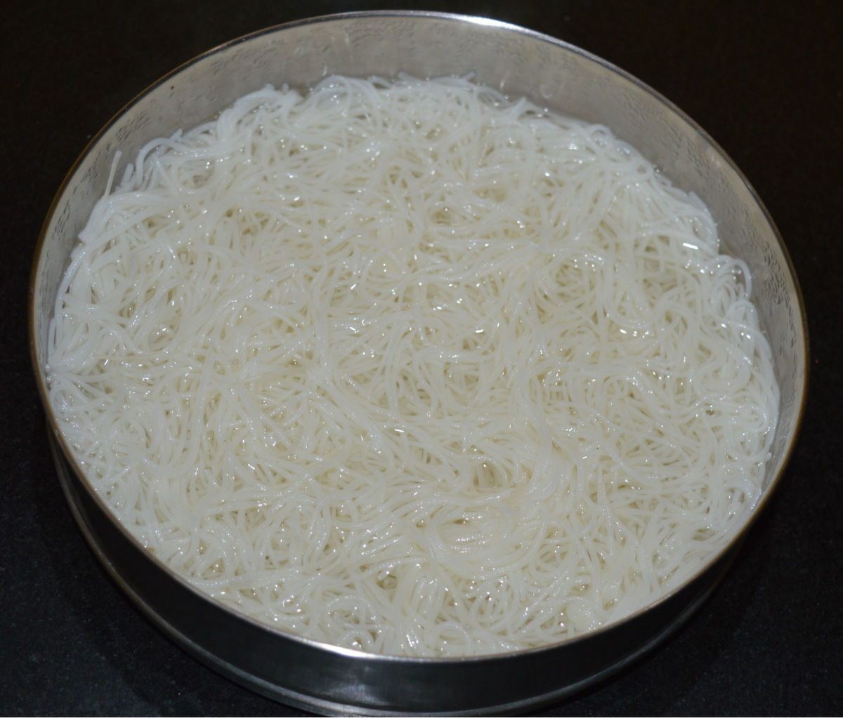 Step one: Pour boiling water on the rice vermicelli. Cover it for 4 minutes. Strain the water. Spread vermicelli on a plate.