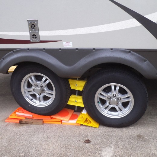 Some campgrounds are built on hillsides and it's tough to level your RV if you don't have the automatic jacks. Getting the right combination of levelers under the right wheels as you go forward, then back, is a royal pain. (This is not the right way)