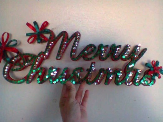 Red and green sequence and ribbon Christmas sign. 