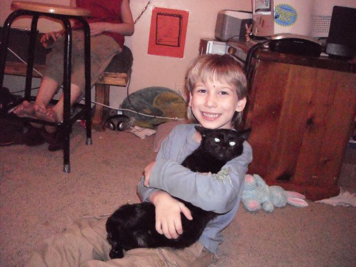 My Little Brother grasping onto our cat Nora. :)