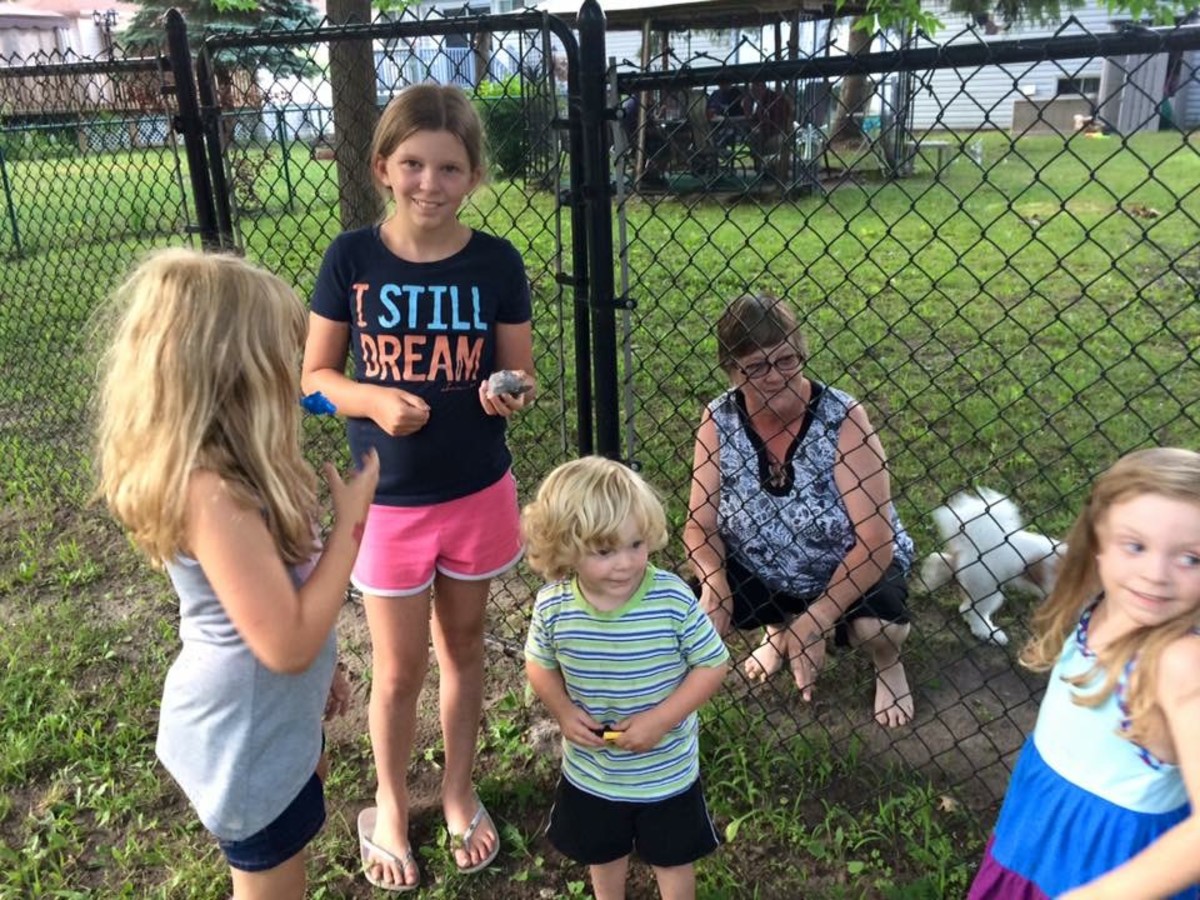 Kids meeting a local neighbor who has a cache hidden at fence.