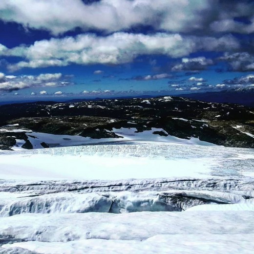 Ice crystals sparkle against shifting clouds and refracting sunlight. 