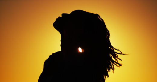 Silhouette of African woman standing at sunset