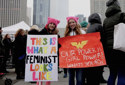 Two young girls holding signs at the 2017 Women's March in Toronto, Canada.