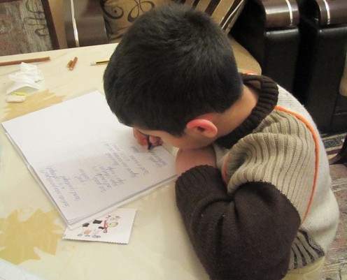 This school-boy is  reading his homework.