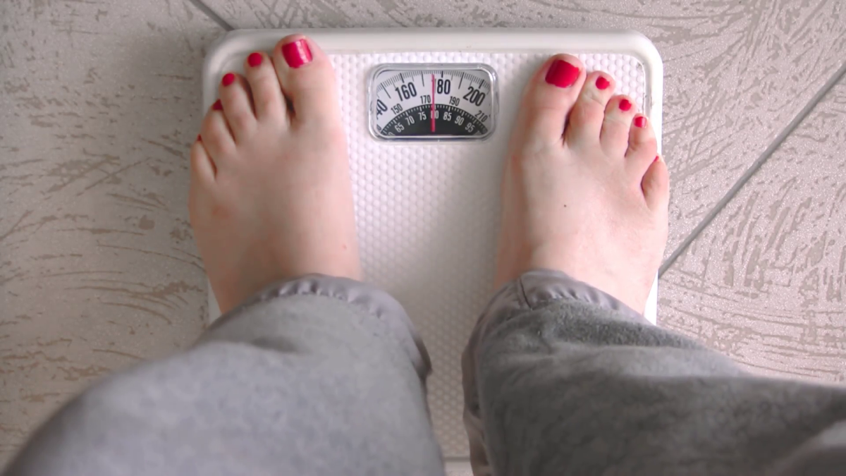 Woman standing on bathroom scales