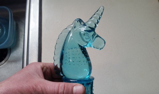 Clear glass creature, like Unicorn, glued to top of votive
