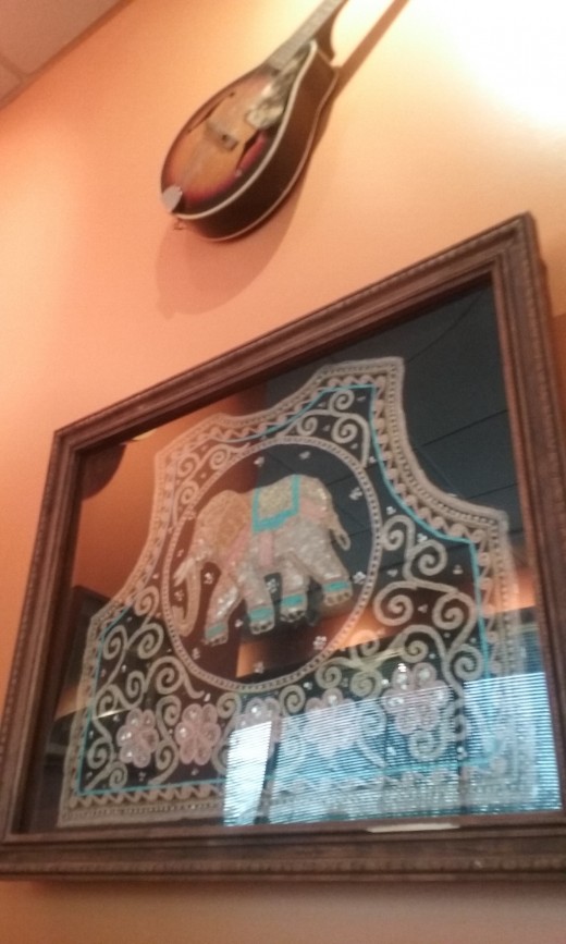 A beautiful embroidered elephant encased in glass frame hangs on the wall at Thai Chiang Mai Restaurant in Greensboro, North Carolina. 