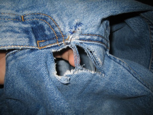A rip or tear in a guy's blue jeans can humiliate a guy with a rip or tear.