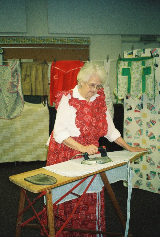 Mom gave talks about the history of aprons to women's clubs, nursing home residents, and other groups. Here she is demonstrating early household skills.