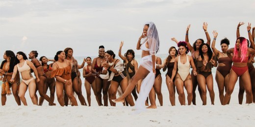 Bride with her 34 bridesmaids on the beach
