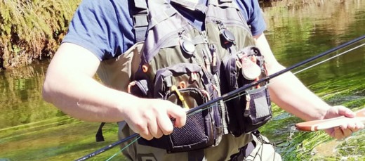Man wearing a fly fishing vest.