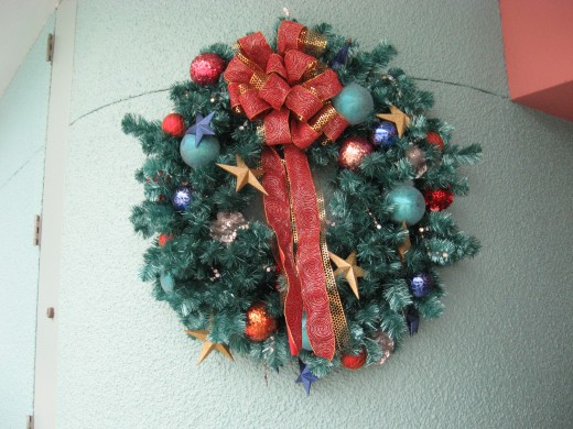 You can take a plain wreath from a craft store and give it a big bow and accents like this one.