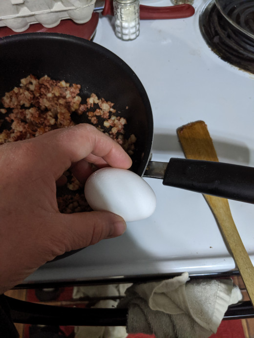 Tap egg on side of pan to break.