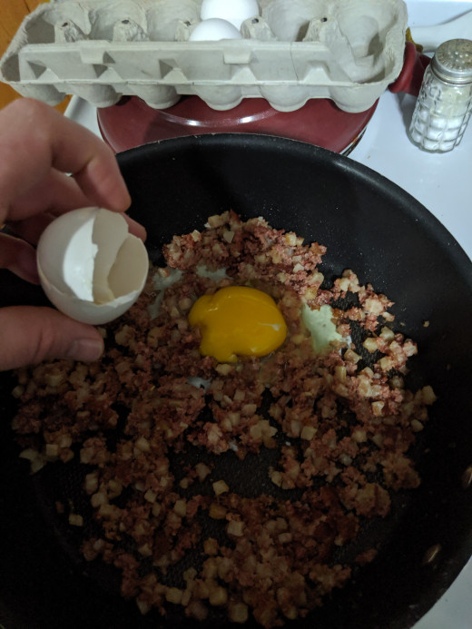 Pour egg onto hash, make sure to remove any shell that drops into the pan.