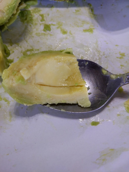 Avocado on spoon preparing to be eaten.