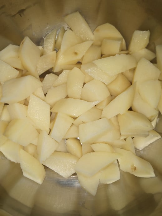 Peel the skin of potatoes and cut into equal sized cubes.