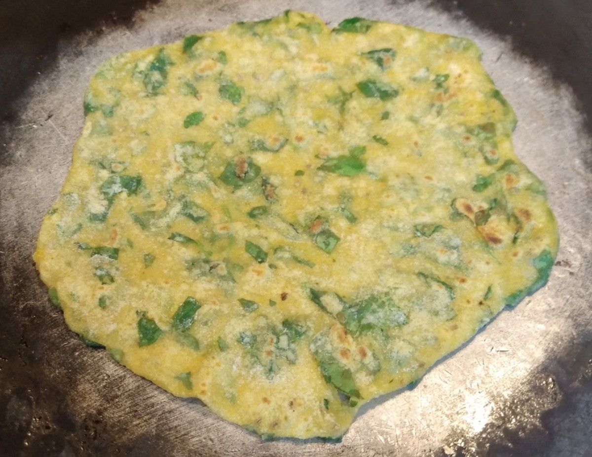 Heat tawa over medium flame. Grease some oil or ghee. Add paratha and fry till golden spots and small bubbles appears.