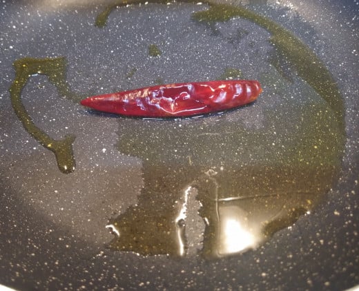 Add dry red chili and fry in low flame till it turns dark in color. (increase the number according to your spice level). Do not burn red chili.