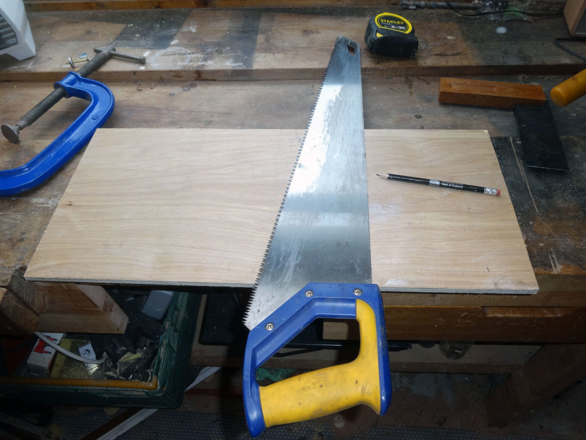 Using the back of the saw as a square, to mark the line for cutting