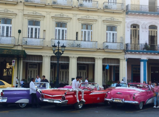 Young men offering tourists a road trip with a beautiful, shining classic American car. Find your car and ask for a trip along the Malecón to enjoy the sunset.  