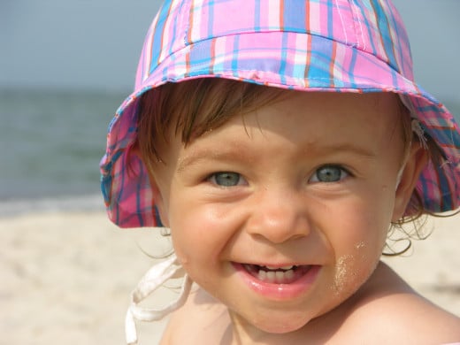 Baby on beach wearing a hat