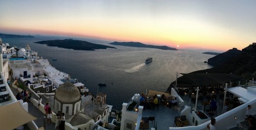 A ship sailing into the sunset at Santorini