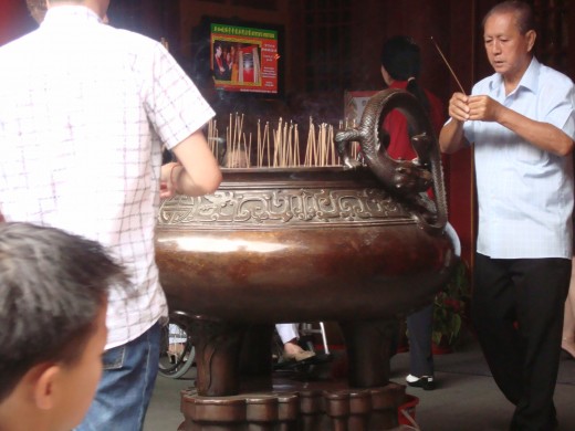 the vat at the entrance with lit joss sticks