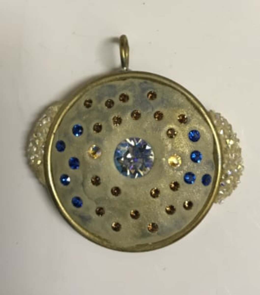 On this pendant - with the bezel filled with clay, chatons embedded, and mica powder brushed on - I attached nail caviar-dipped pieces of fresh clay on the sides. 