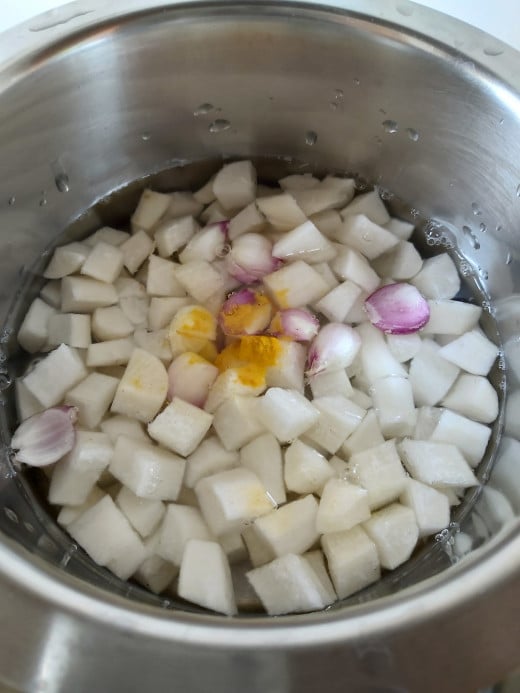 Add 2 cups of water or as required, add 1/2 teaspoon of turmeric powder, add salt to taste, cover and cook over medium flame till radish is tender.