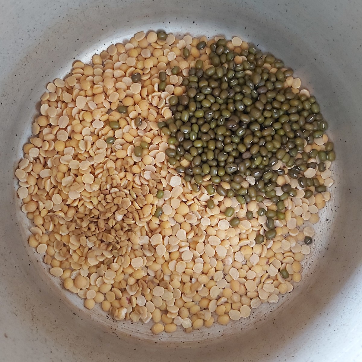 Take 1/2 cup of toor dal (pigeon pea lentils). 2-3 teaspoons of green gram and 1/2 teaspoon of fenugreek seeds in a cooker.