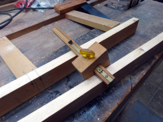Using a marking gauge to mark where to drill the holes for fitting the dowels. 