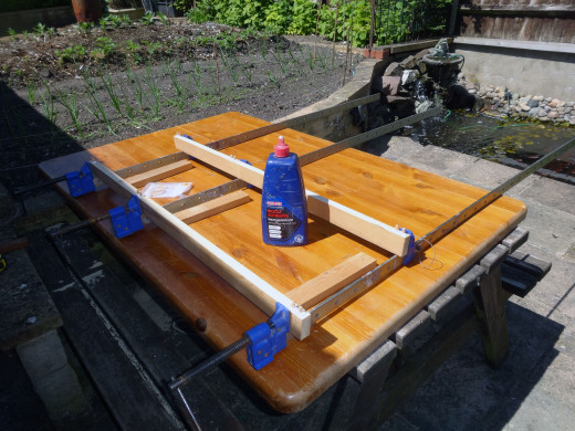 Gluing the dowels in place, so that the frame for the front panel can be fitted together and clamp while the glue sets.