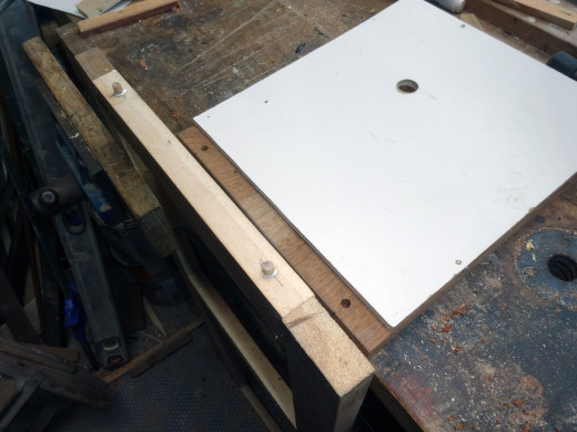 To help hold the front panel tightly in place:  Fitted two dowels, one at each end on the base of the front panel as lugs, and then drilled two corresponding holes in the bottom shelfs to marry up with the lugs.